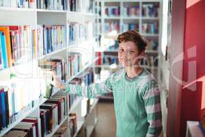 Schoolboy selecting book in library