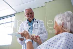 Doctor serving breakfast and medicine to senior patient