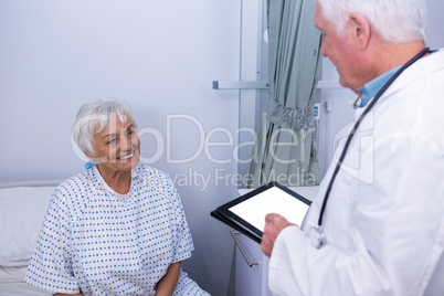 Doctor interacting with senior patient in ward