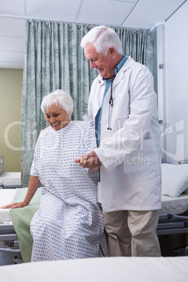 Doctor assisting senior patient at hospital