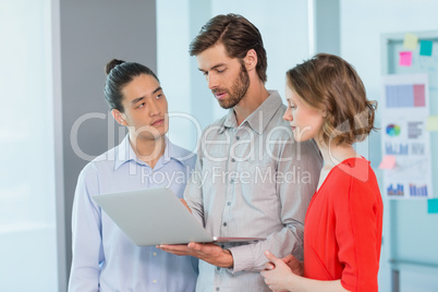 Business executives discussing over laptop