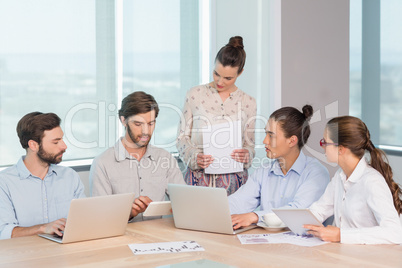 Business executives discussing with each other in conference room