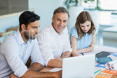 Architects discussing over laptop in conference room