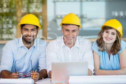 Smiling architects sitting together in conference room