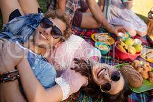 Happy couple relaxing in the park while having picnic