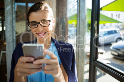 Female executive using mobile phone in cafÃ?Â©