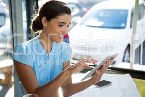 Female executive using digital tablet at cafÃ?Â©