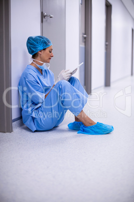 Surgeon sitting on floor and using digital tablet