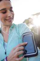 Female jogger listening to music on mobile phone