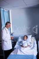 Male doctor interacting with patient during visit in ward