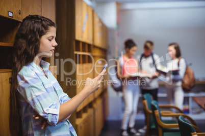 Schoolgirl using mobile phone in locker room