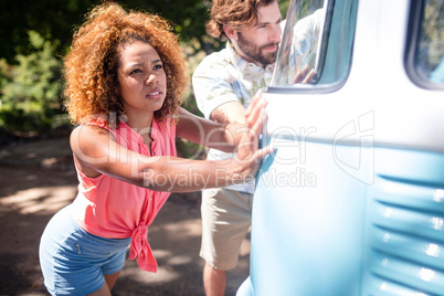 Couple pushing a campervan