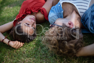 Couple lying on grass in park