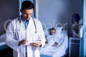 Doctor using digital tablet in ward