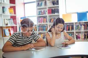 Students using digital tablet in library