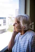 Thoughtful senior patient looking through window
