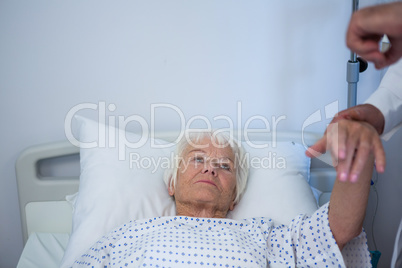 Doctor examining senior patient in ward