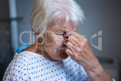 Tensed senior patient standing at hospital