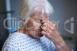 Tensed senior patient standing at hospital