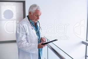 Doctor using a digital tablet in the passageway