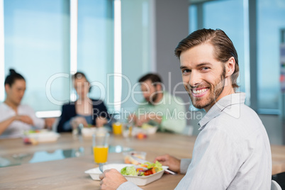 Smiling business executive having meal in office