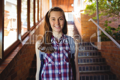 Portrait of schoolgirl to schoolbag standing near staircase