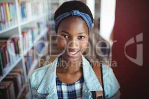 Portrait of schoolgirl smiling in library