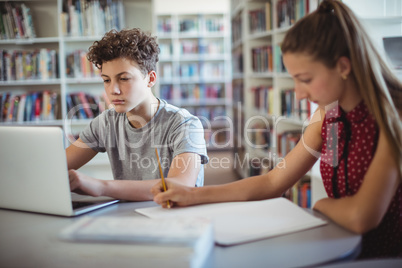 Classmates doing homework in library