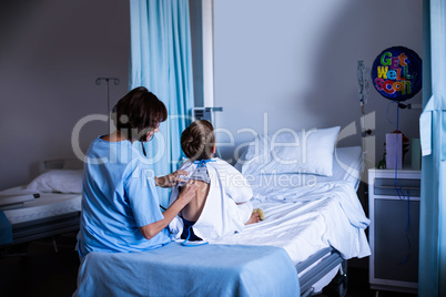 Female doctor examining patient with stethoscope