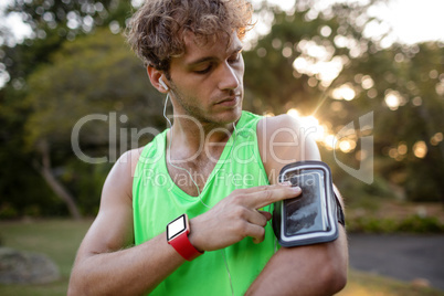 Male jogger listening to music on mobile phone