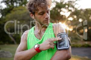 Male jogger listening to music on mobile phone