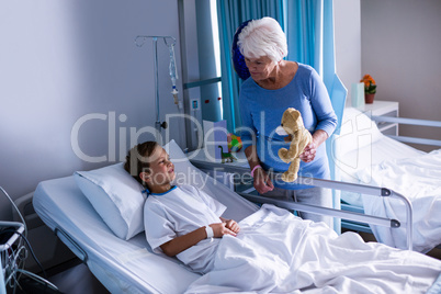 Grandmother showing teddy bear to grandson