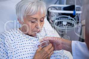 Doctor giving glass of water to seniorÃ?Â patient