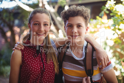 Portrait of happy classmates standing with arms around