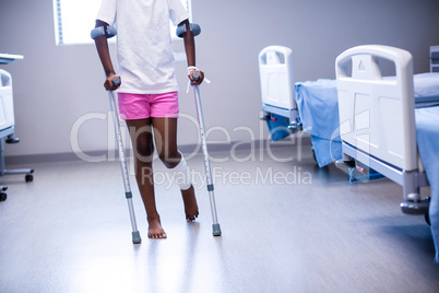 Girl walking with crutches in ward
