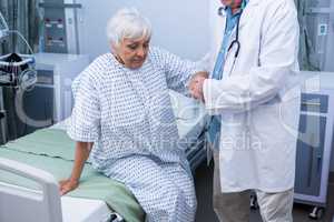 Doctor assisting senior patient at hospital