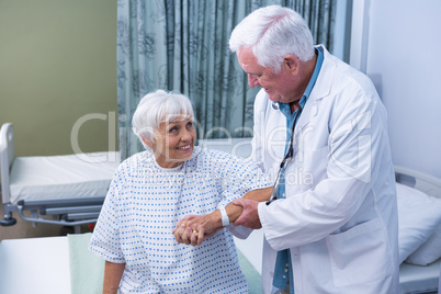 Doctor assisting senior patient at hospital