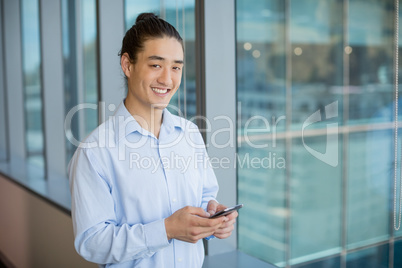 Business executive using on mobile phone in corridor