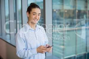 Business executive using on mobile phone in corridor