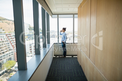 Business executive talking on mobile phone in corridor