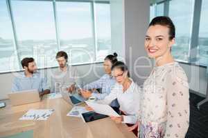 Portrait of smiling female business executive standing in conference room
