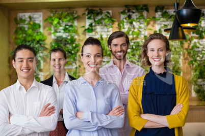 Business executives with arms crossed standing in office