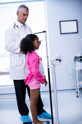 Doctor measuring height of girl