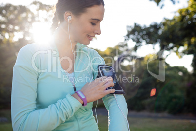 Female jogger listening to music on mobile phone
