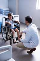 Male doctor interacting with child patient in ward