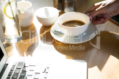 Woman holding coffee cup at cafÃ?Â©