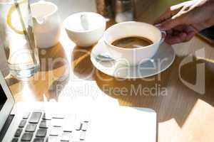 Woman holding coffee cup at cafÃ?Â©