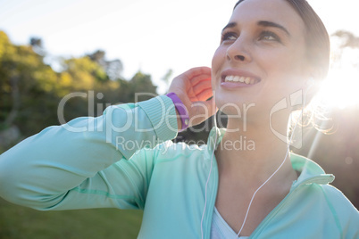 Close-up of smiling female jogger with headphones taking a break from exercise