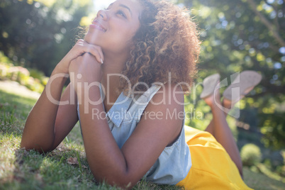 Thoughtful woman lying on a grass