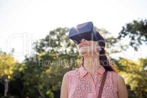 Smiling woman using a VR headset in the park